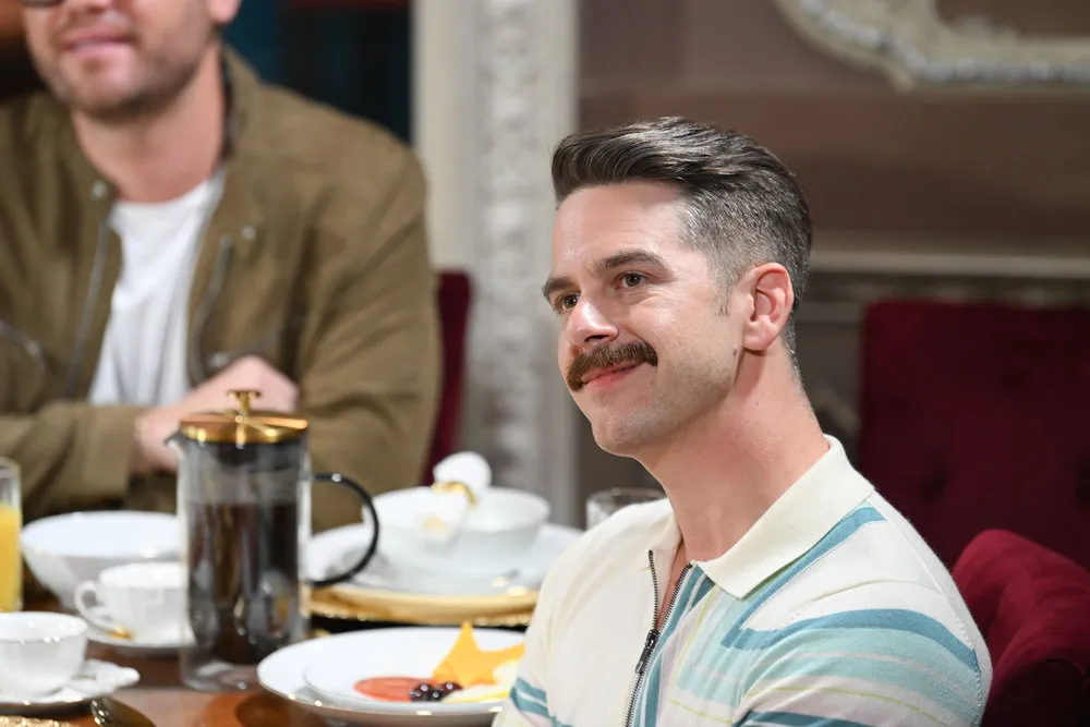 'The Traitors: New Blood' contestant Jay sits at a table.
